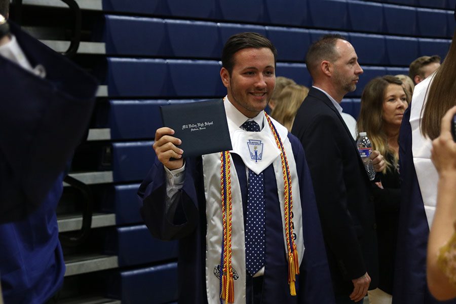 Graduate Jacob Hoffman poses for a picture with his diploma.