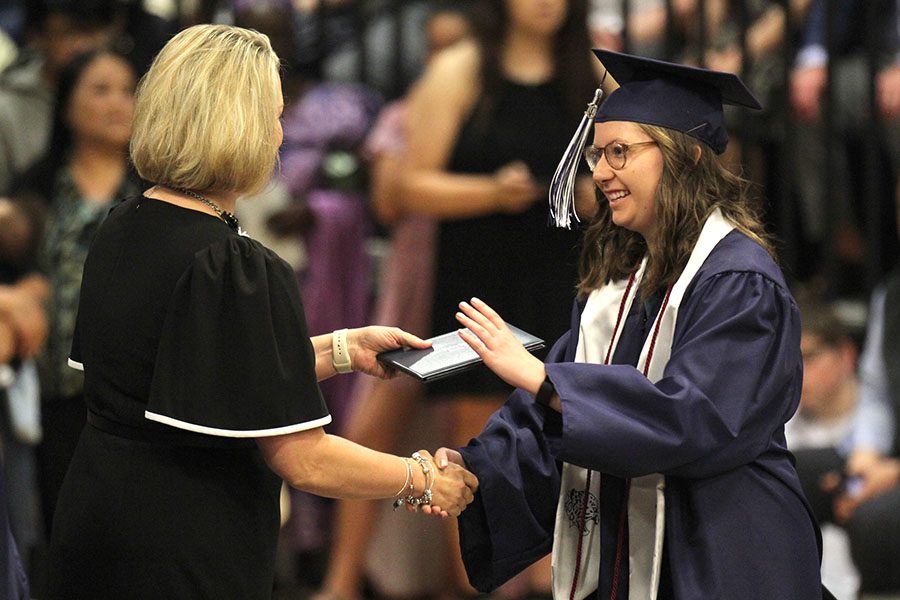 While accepting her diploma, senior Katya Gillig shakes a school board members hand. 