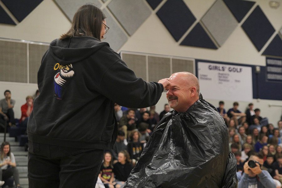 Preparing to pie principal Tobie Waldeck in the face, band director Deb Steiner paints whipped cream onto his forehead. Steiner received the honor after bringing in the most mobility devices for the Crutches for Africa drive, hosted by Youth for Refugees.