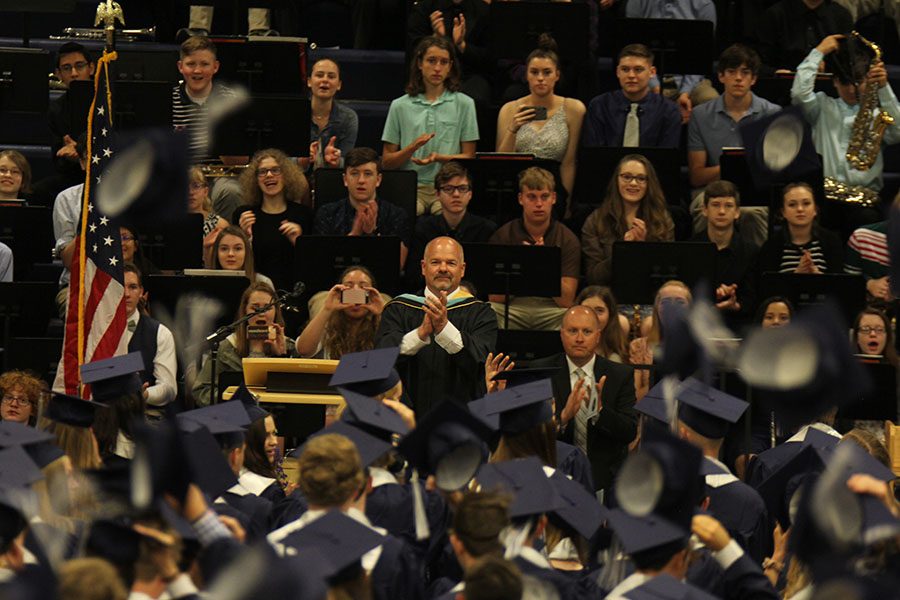 As the seniors threw their caps, principal Tobie Waldeck claps for them. 