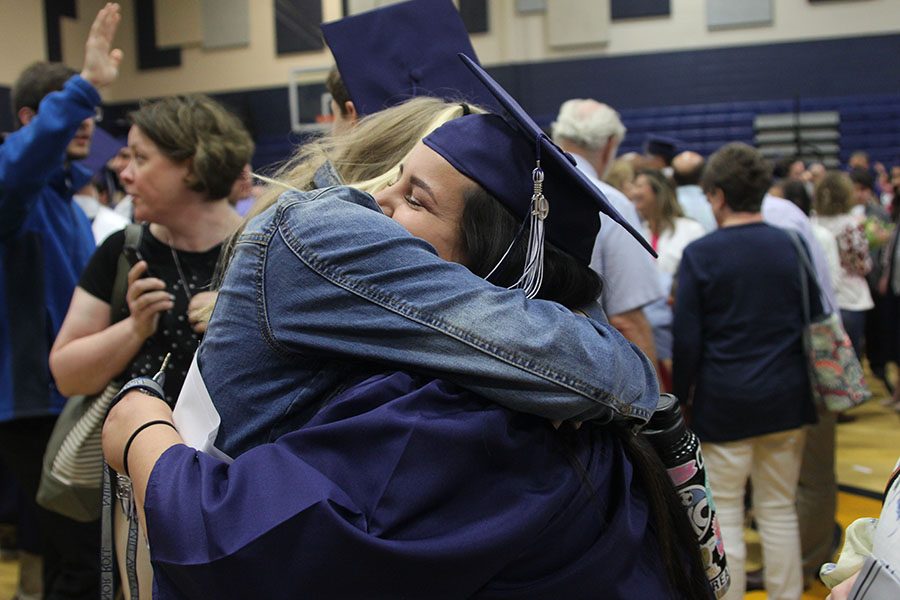 Hugging a friend, senior Claire Segura celebrates graduating. 