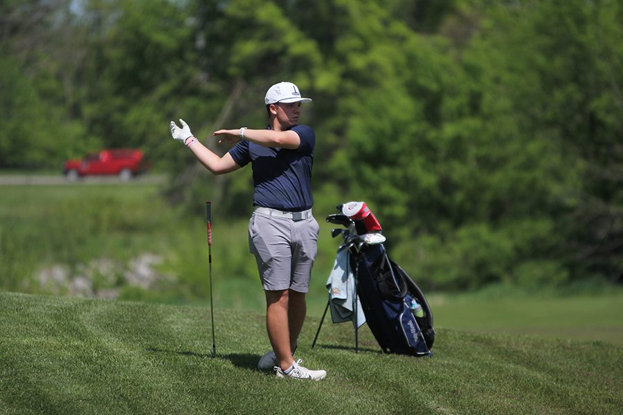 Along the green of hole 9, junior Charlie Flick watches  for where his shot will land.