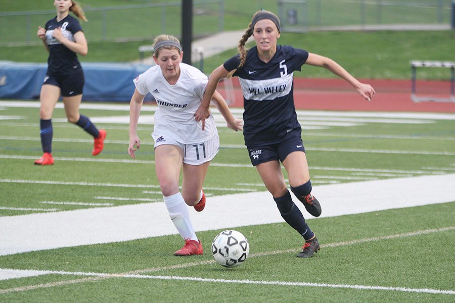 Managing to keep her opponent back, junior Annie Hoog chases after the ball on Wednesday, May 1.