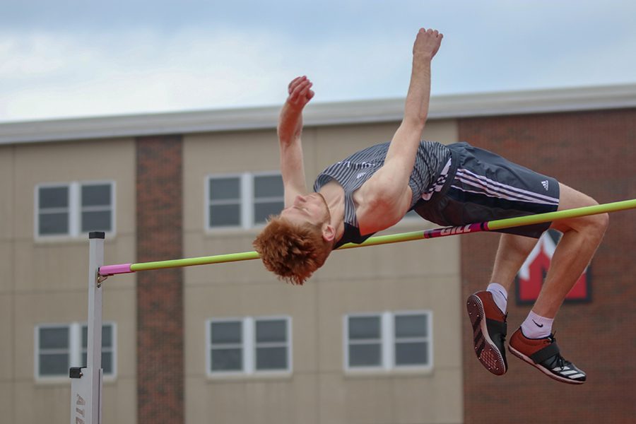Throwing his arms in the air, junior Braedan Wiltse clears the bar. 