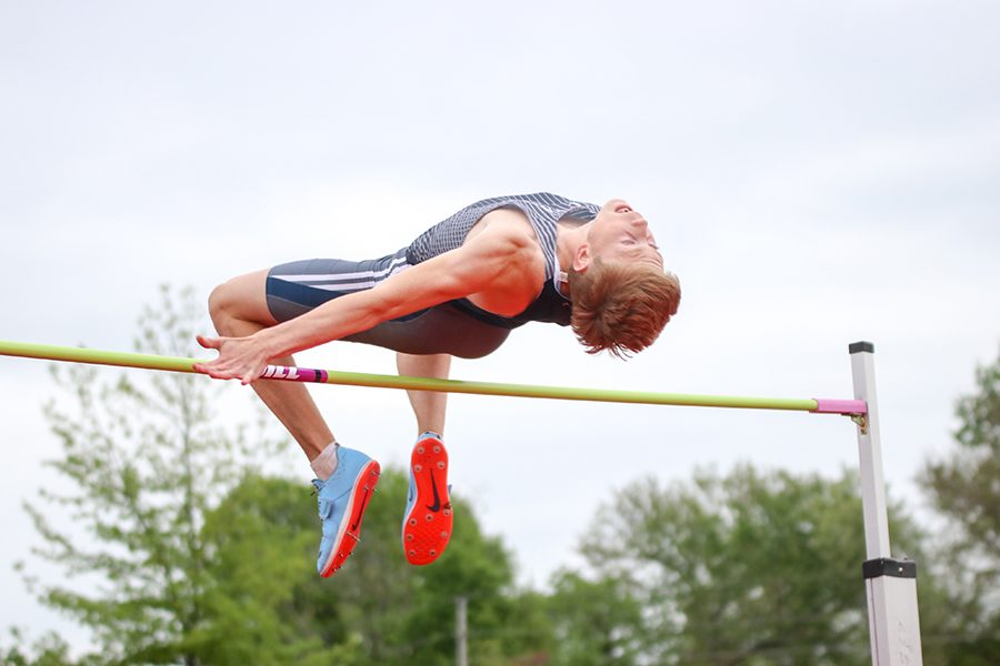 After jumping, senior Harry Arenholtz arches his back to clear the bar. Arenholtz finished second in the high jump. 