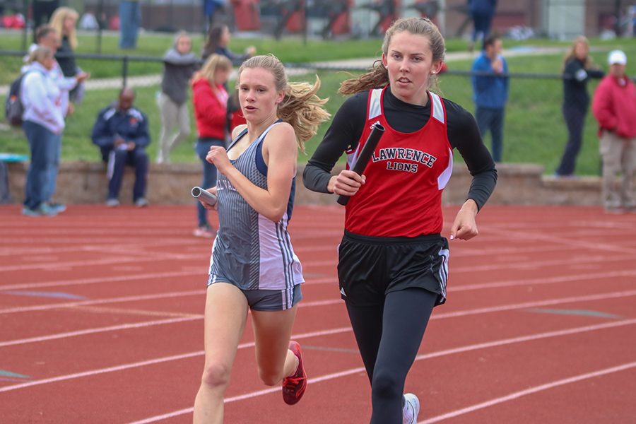Coming around turn one, freshman Katie Schwartzkopf passes a Lawrence High School in the 4x800 meter relay. The relay team finished first. 