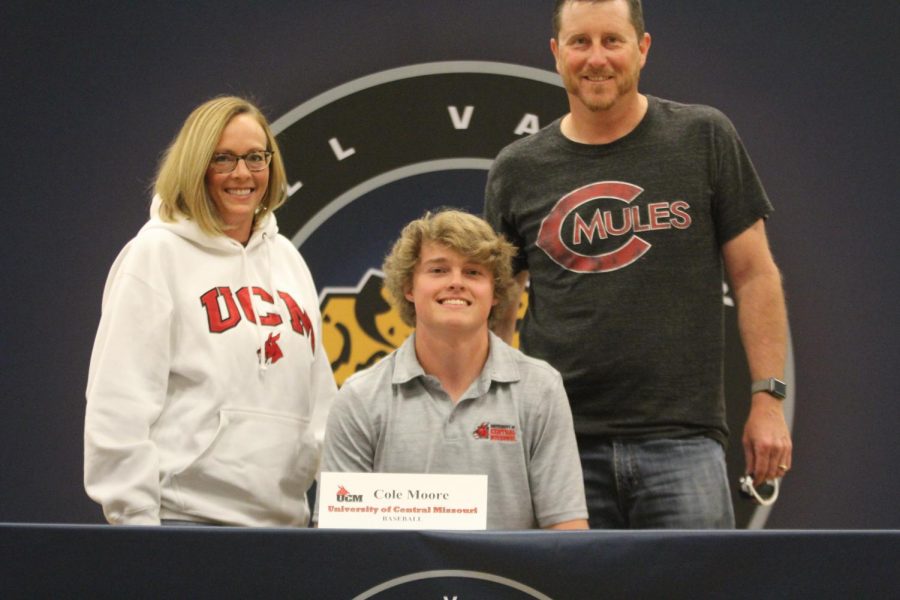 After signing to play baseball at Central Missouri State, Cole Moore smiles with his parents.