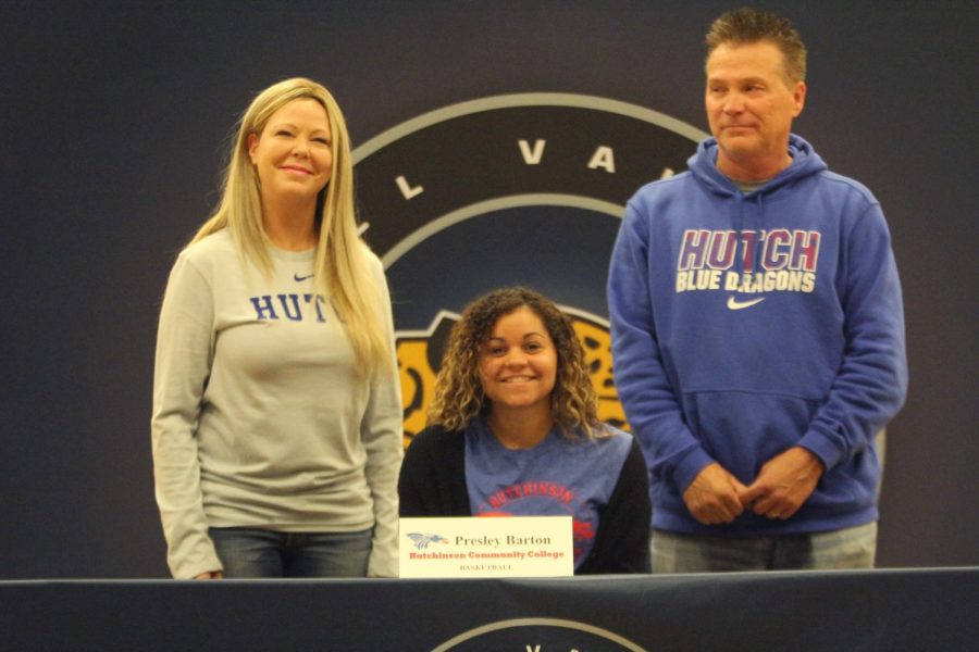 After signing to play basketball at Hutchison Community College, Presley Barton smiles with her parents.