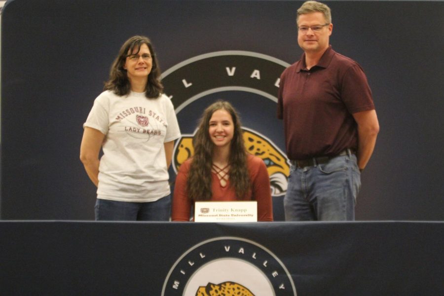 After signing to play basketball at Missouri State University, Trinity Knapp smiles with her parents.