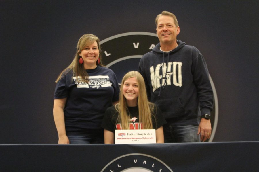 After signing to cheer for Mid-America Nazarene, Faith Dmyterko smiles with her parents.