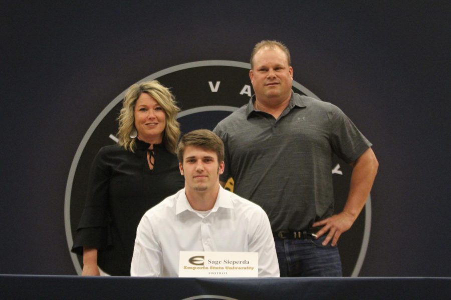 After signing to play football at Emporia State University, Sage Sieperda smiles with his parents.