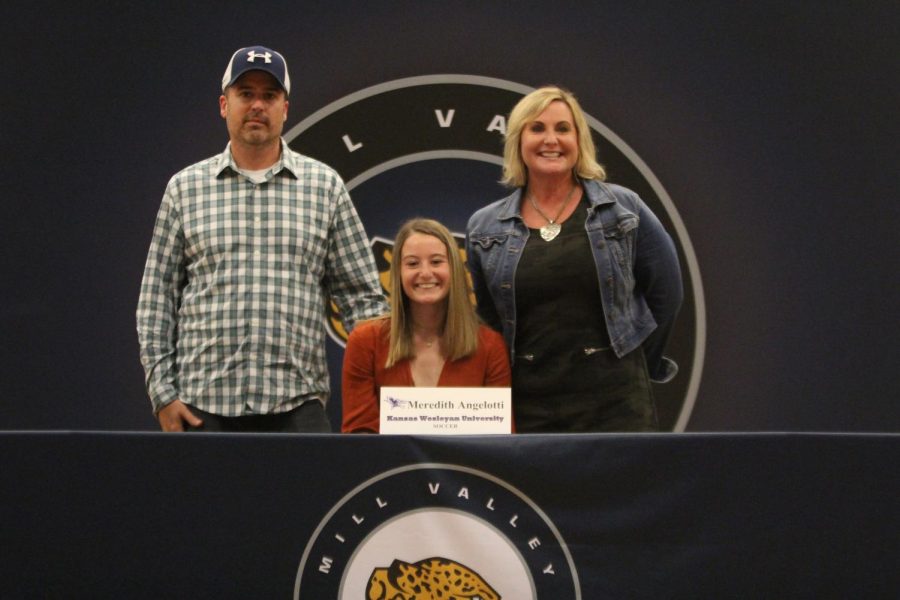 After signing to play soccer at Kansas Weslyan, Meredith Angelotti smiles with her parents.