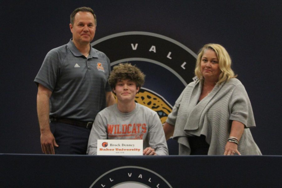 After signing to play soccer at Baker University, Brock Denney smiles with his parents.
