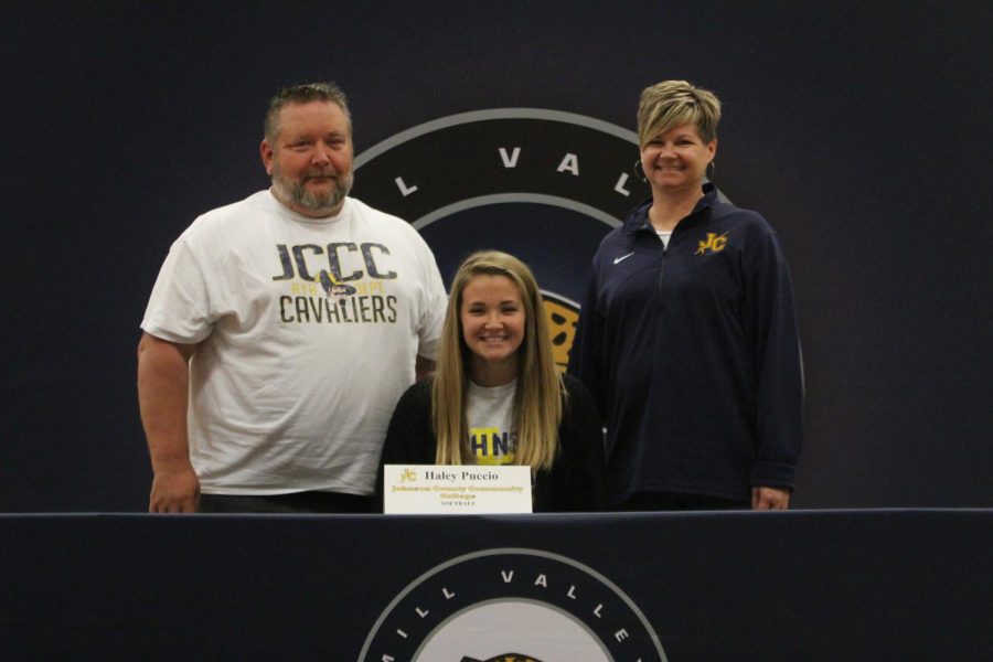 After signing to play softball at Johnson County Community College, Haley Puccio smiles with her parents.