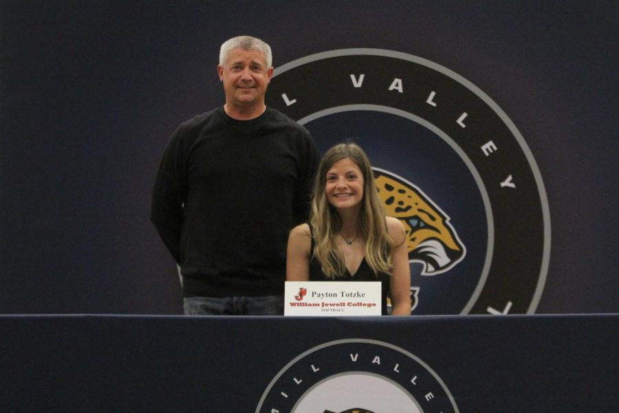 After signing to play softball at William Jewell College, Payton Totzke  smiles with her father.