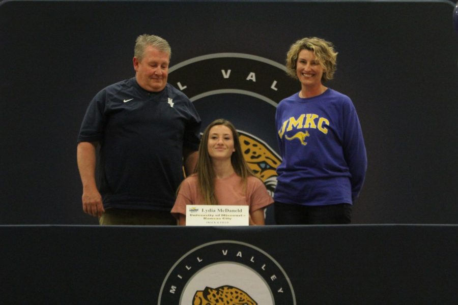 After signing to compete in track and field at UMKC, Lydia McDaneld smiles with her parents.