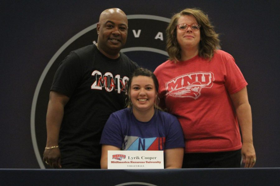 After signing to play volleyball at Mid-America Nazarene University, Lyrik Cooper smiles with her parents.