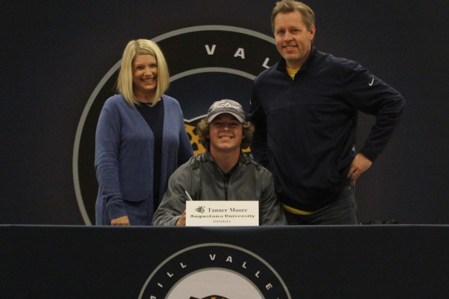 After signing to play football at Augustana University, Tanner Moore smiles with his parents.