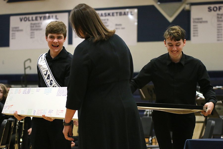 Before the last song, seniors Johannes Seberger and Zach Bossert present Steiner with a personalized shelving unit for the band room.