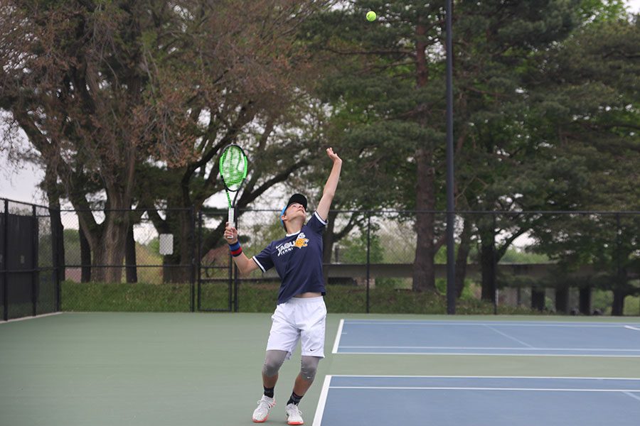 In his singles match, freshman Gage Foltz serves the ball. 