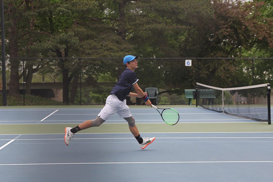Bringing down his racket, freshman Gage Foltz steps towards the net. 
