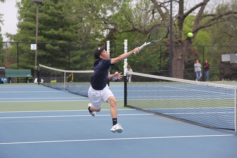 Jumping, senior Eric Schanker returns the ball.
