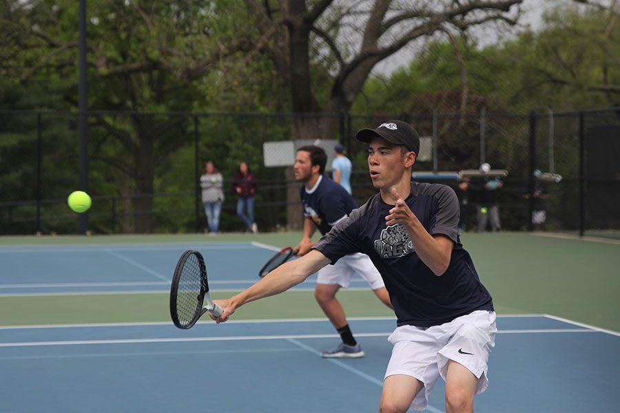 With his arm out, senior Eric Schanker returns the ball.
