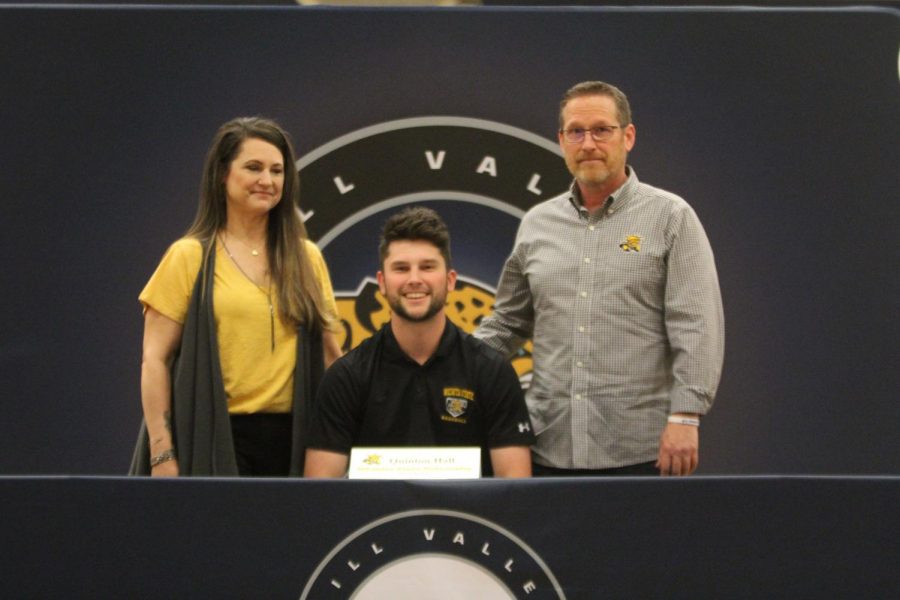 After signing to play baseball at Wichita State University, Quinton Hall smiles with his parents.