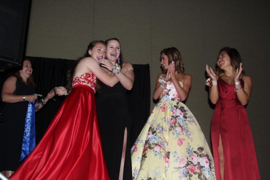 Following being announced prom queen, senior Marah Shulda is embraced by friend senior Delaney Kemp.