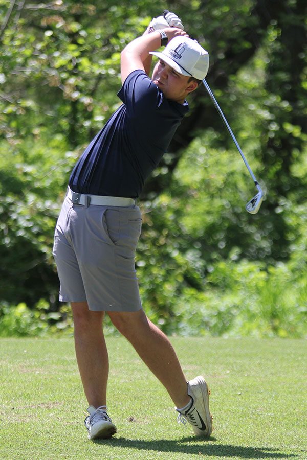 Standing at the beginning of the hole, junior Charlie Flick takes his first swing.