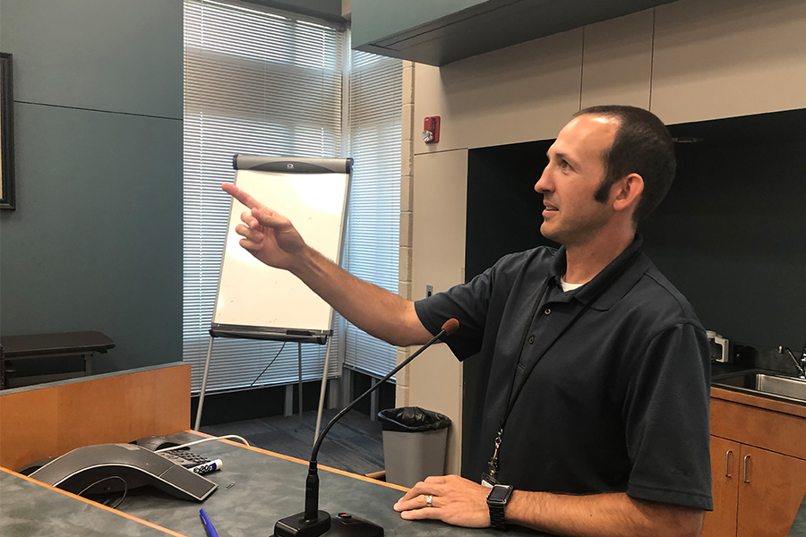 District technology director Brandon Riffel gestures as he lays out the new MacBook handbook. 