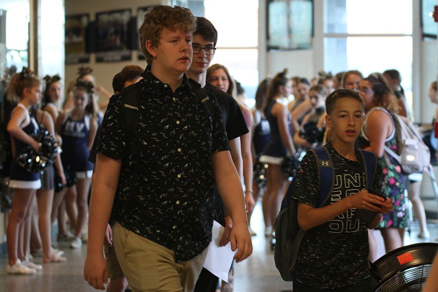 A group of freshmen walk to the auxiliary gym to get their school pictures taken.