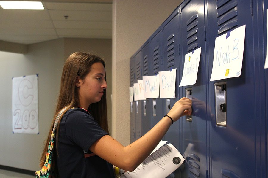 A freshman practices opening her locker for the first time.
