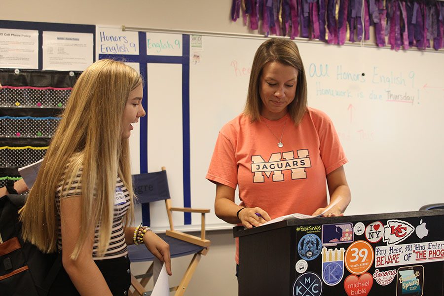 English teacher Ashley Agre looks to see if a freshman Sienna DelBorrell is in her Honors English 9 class.
