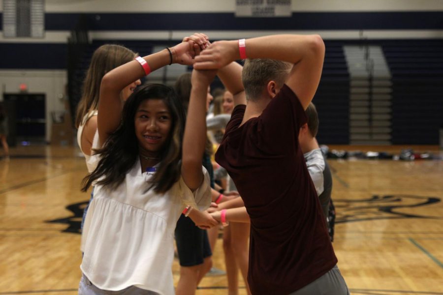 Two freshmen practice a spin while dancing together.
