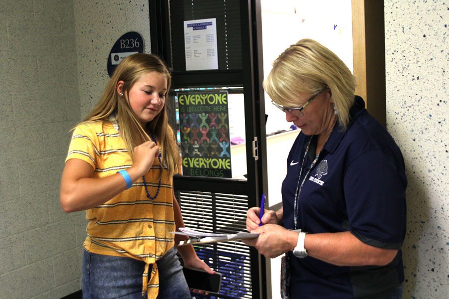 Freshman biology teacher Betsy Meeks signs a freshman Haley Bryants class scavenger hunt paper Wednesday, Aug. 14, 2019.