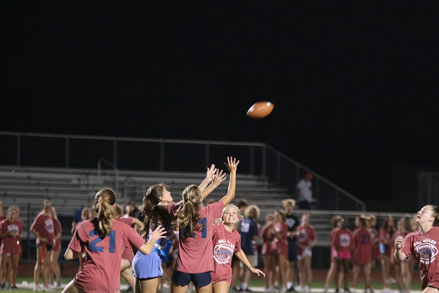 Multiple juniors try to stop senior girl from catching the ball. 
