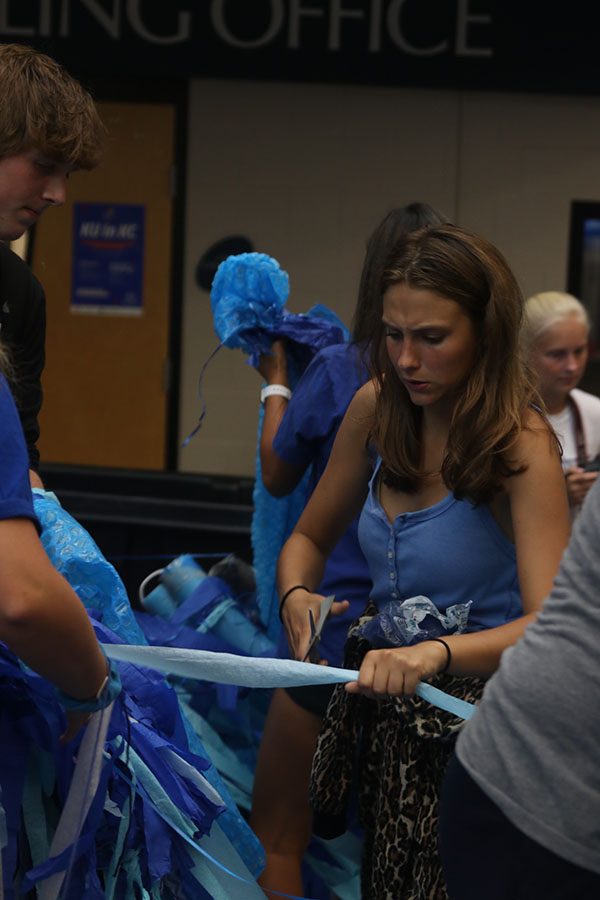 Along with many classmates, senior Avery Altman helps clean up the blue mess. 