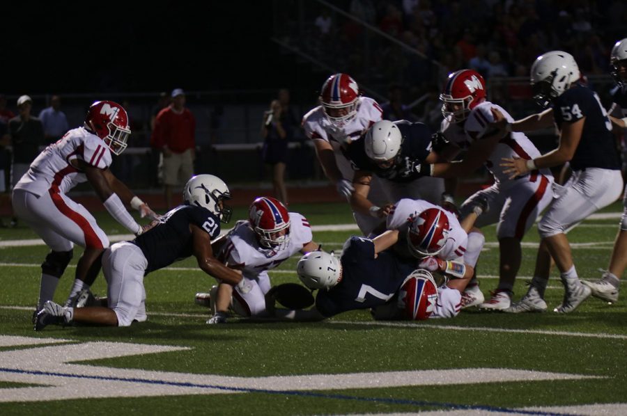 Junior quarterback Cooper Marsh extends his arm over the goal line for a touchdown, cutting the Jaguar deficit against Bishop Miege to seven points. 