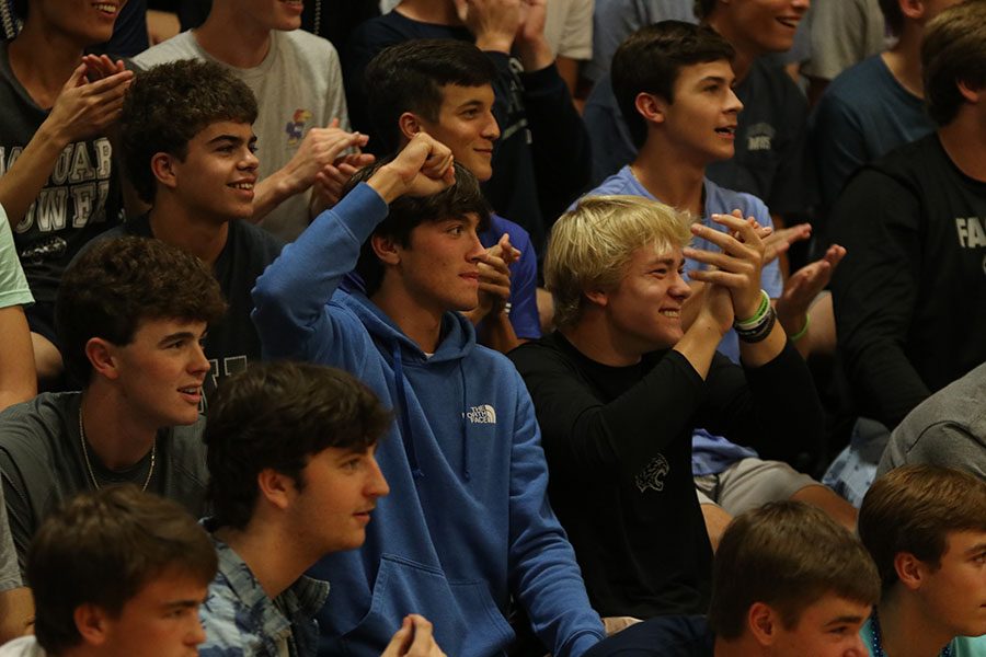 Cheering, seniors Anthony Pentola and Grant Frost watch as the homecoming candidates are introduced.