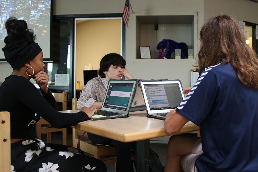 Working together in the library, seniors Aidan Thomas and Daniella Phale and sophomore Cameron Long check to see if any teachers need their assistance.