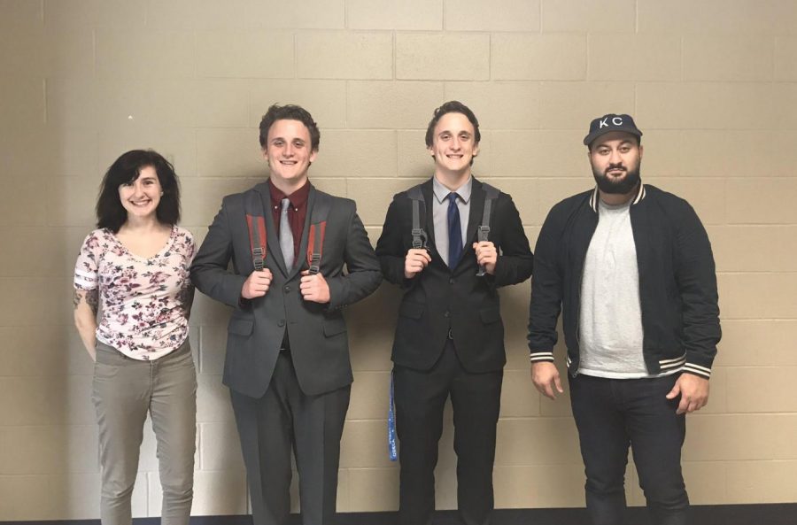 Grinning at their success, seniors Thomas and Travis Babcock stand for a photo with their coaches for the debate teams Twitter page. The duo made it to octofinals and earned a DCI bid at the  Washburn Rural Debate Invitational Sunday, Sept. 22. 