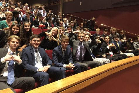 Waiting for the ceremony to begin, the team displays the DECA hand sign. The team competed Tuesday, Sep. 17 at Johnson County Community College.