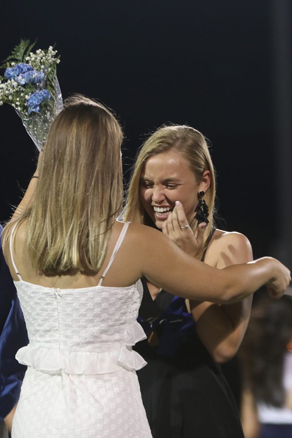 Laughing, homecoming queen winner Ashlyn Dempsey is crowned by previous queen Lilli Milberger. 