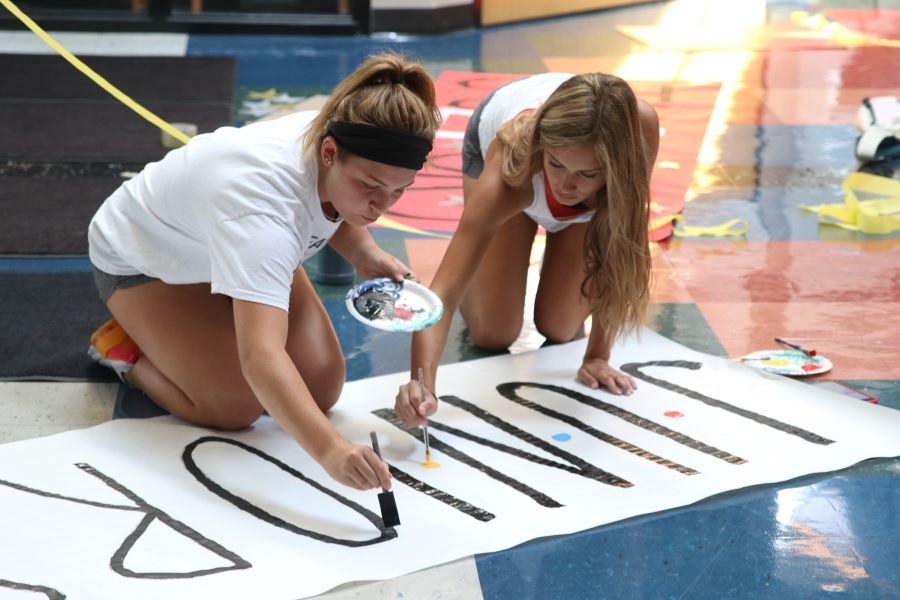 Juniors Grace Moser and Avery Rutkowski paint a sign to hang by the junior locker banks.