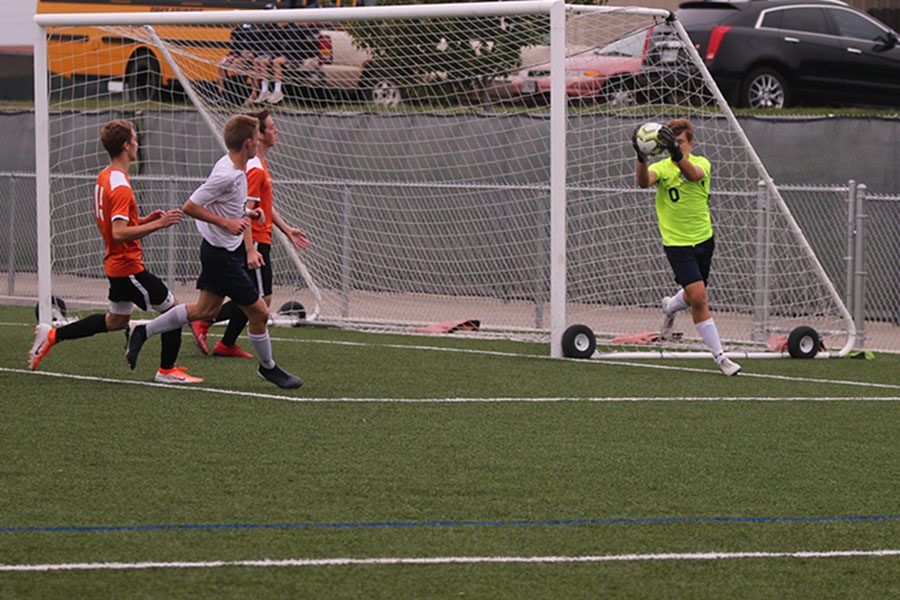 After a loose ball is shot at the goal, freshman Colin Riley catches the ball and pulls it to his chest. 