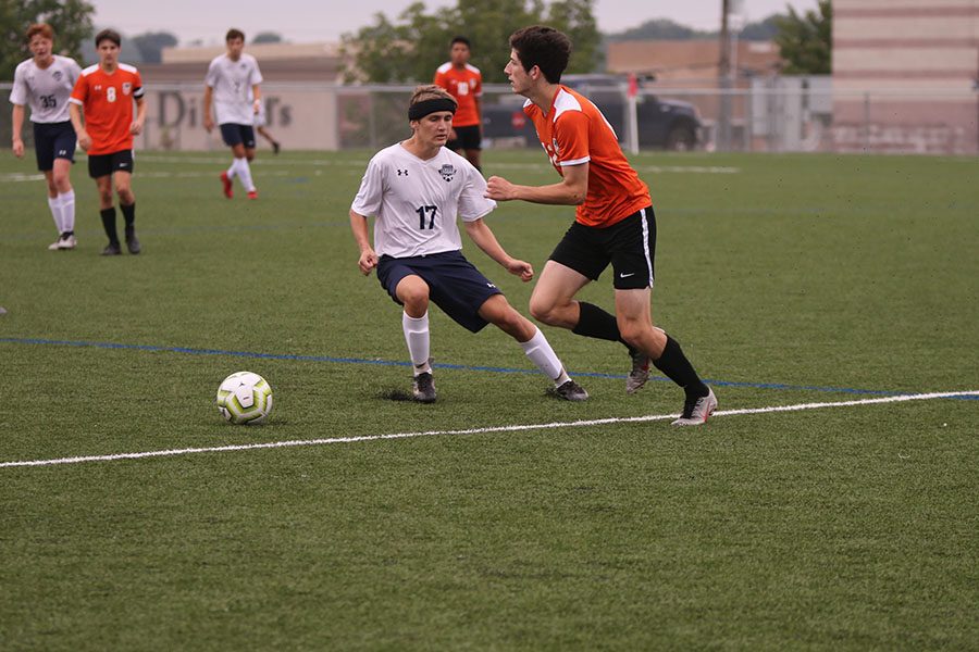 Shuffling his feet, junior Dace Riddle  keeps in line with his opponent in attempt to block him. 