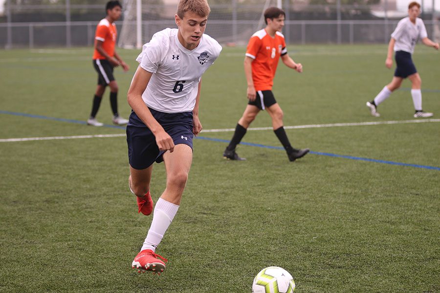 After receiving a pass from his teammate, sophomore Garrison Schrag pushes the ball up field.  