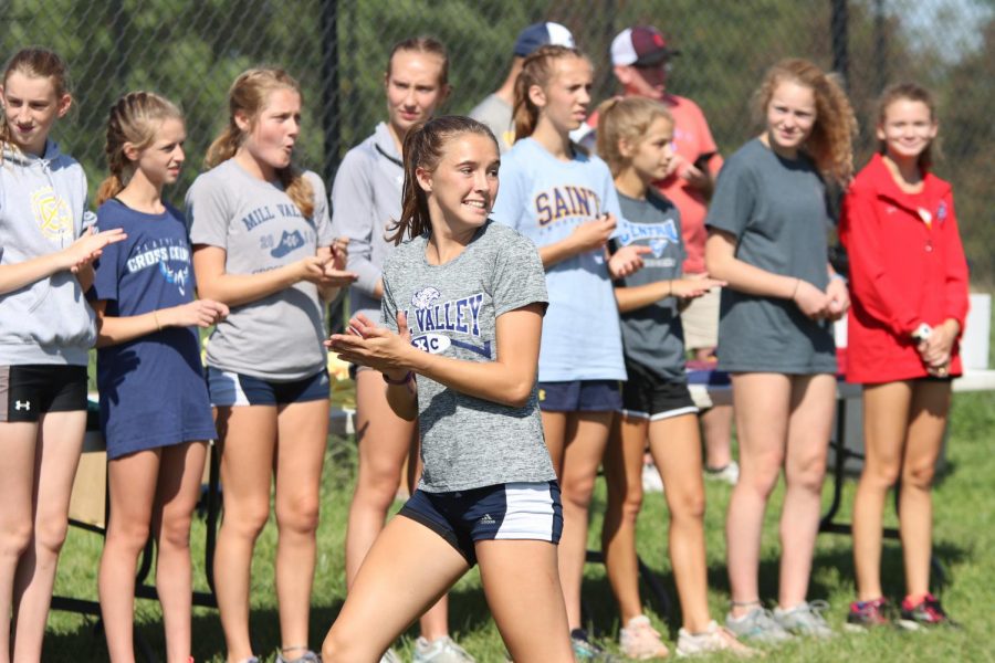 Going to receive her medal, senior Molly Haymaker cheers on her teammates.