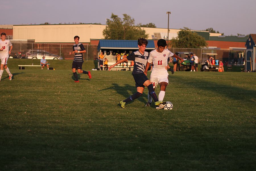 Trying to get the ball away from his opponent, sophomore Yahel Anderson pushes the ball over an opposing player’s foot. 
